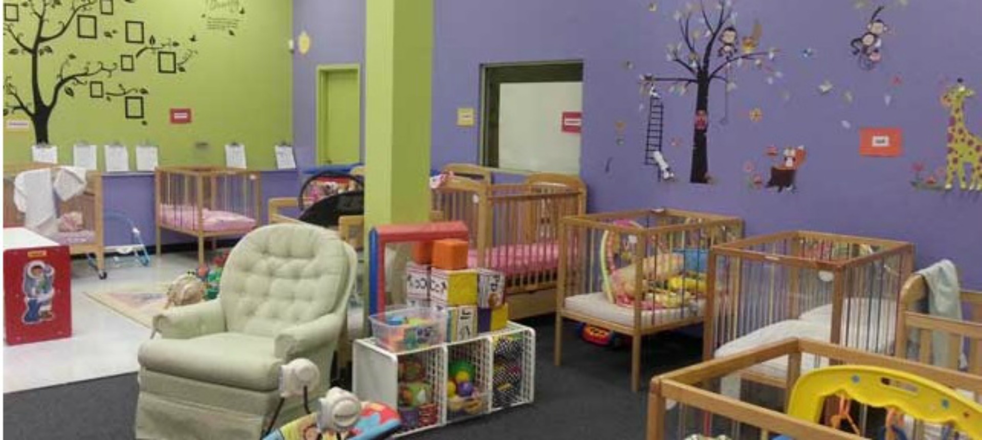 Infant room has cribs, floor play areas, soft toys